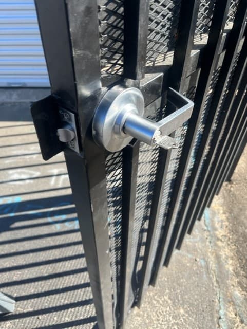 Commercial-grade lock and lever installed on a steel security gate