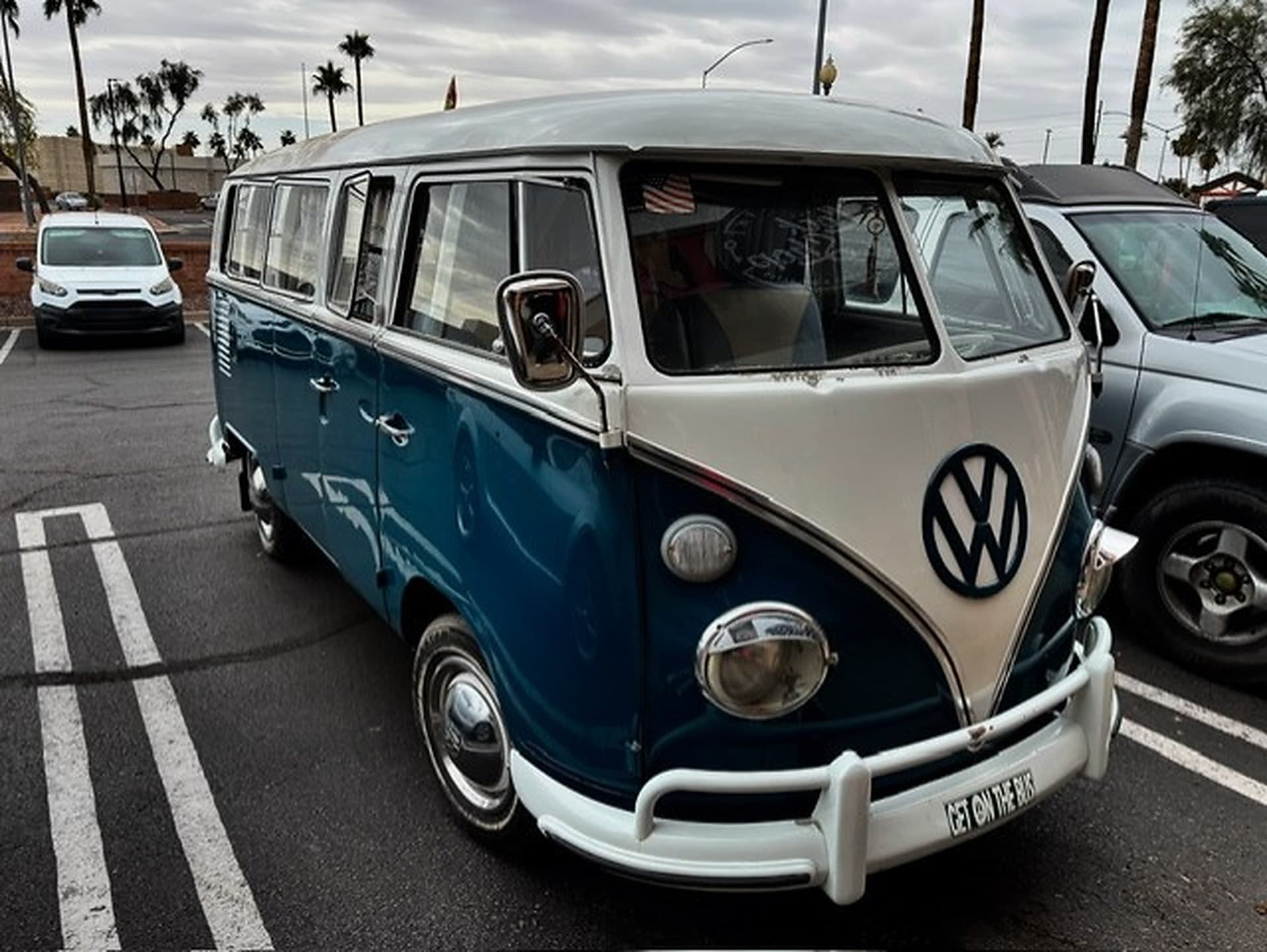 Blue and white Volkswagen bus parked in a lot