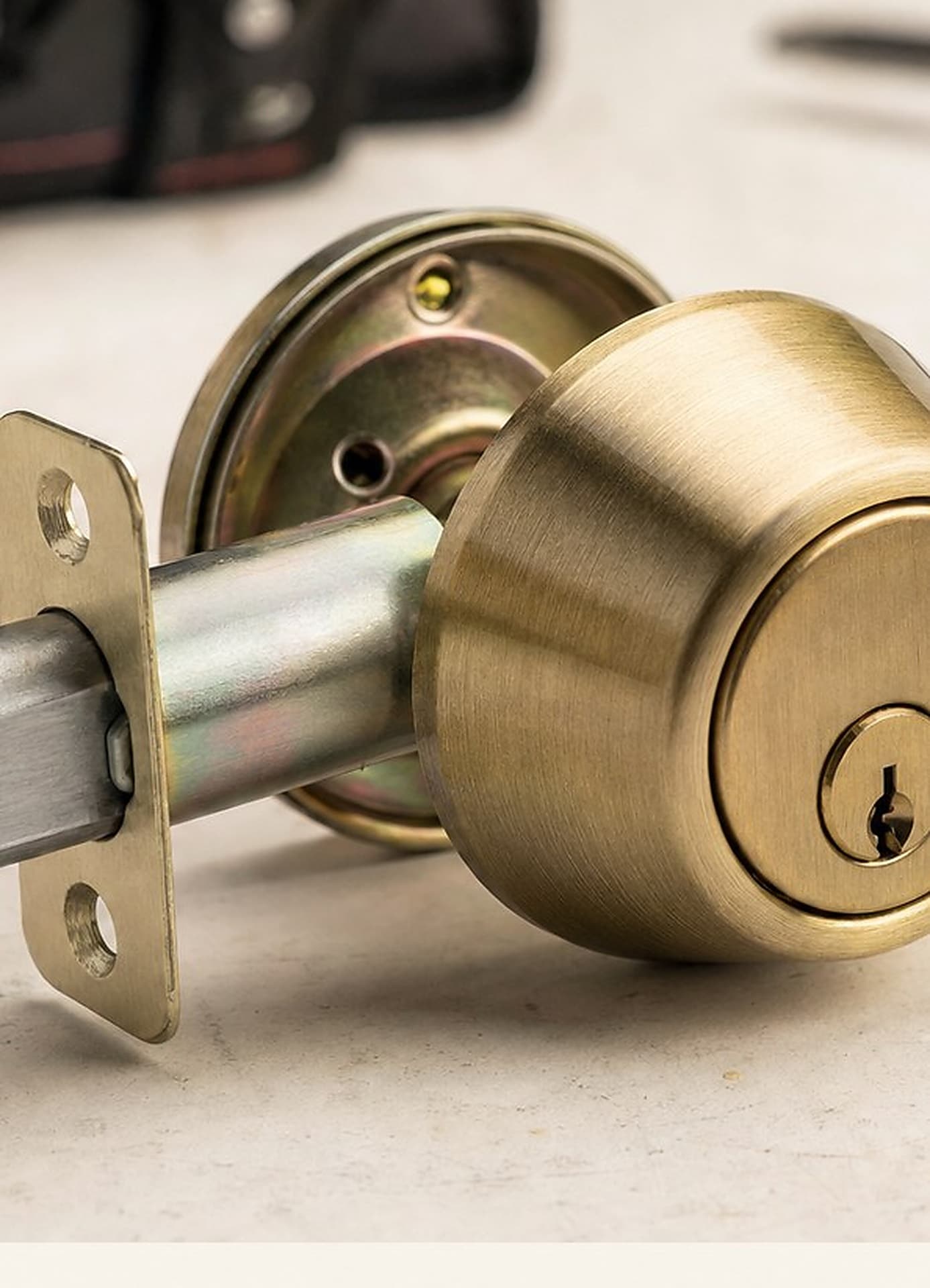 Brass deadbolt with latch bolt on a light work surface