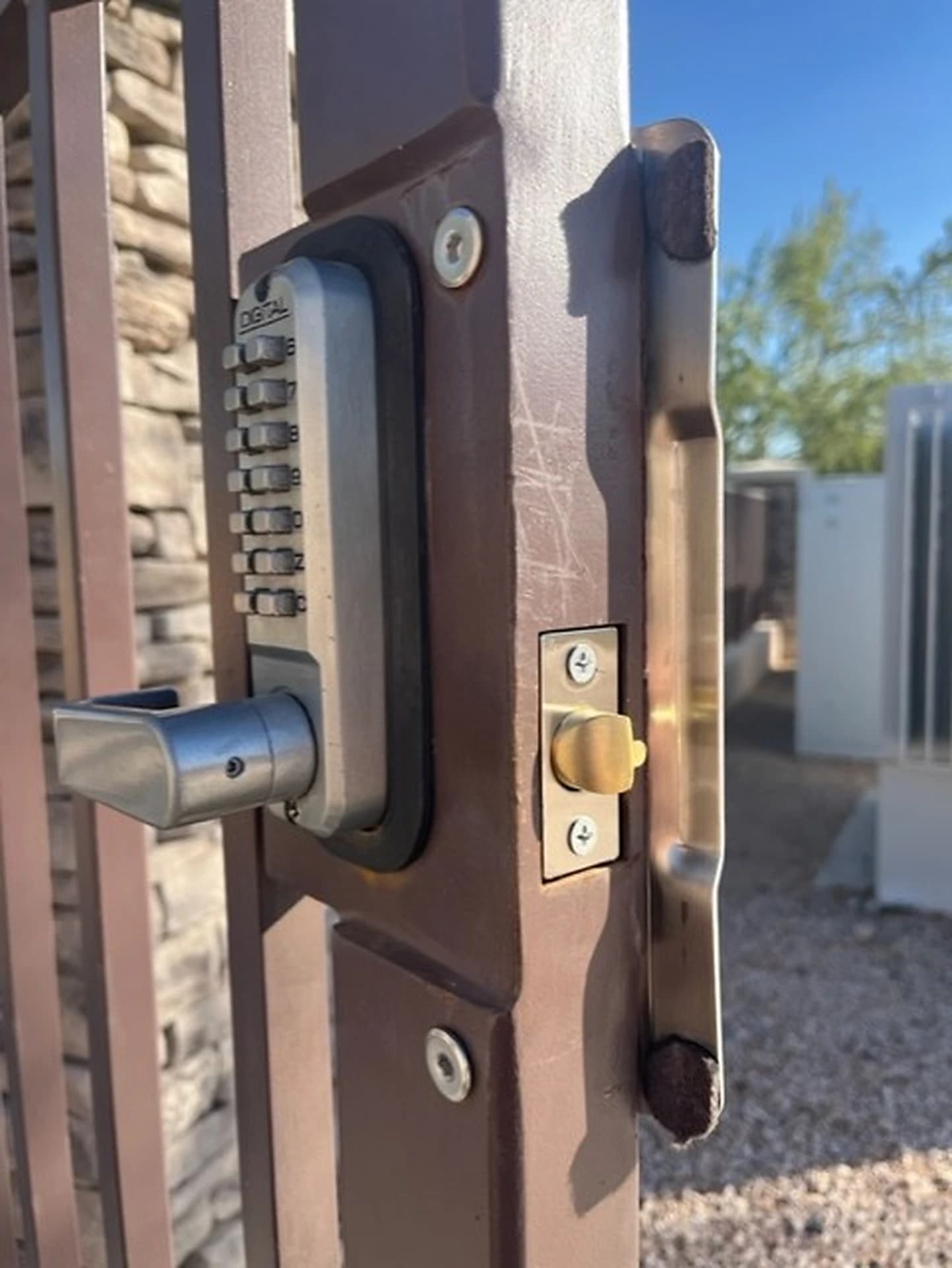 Mechanical push-button keypad lock and latch mounted on a metal gate